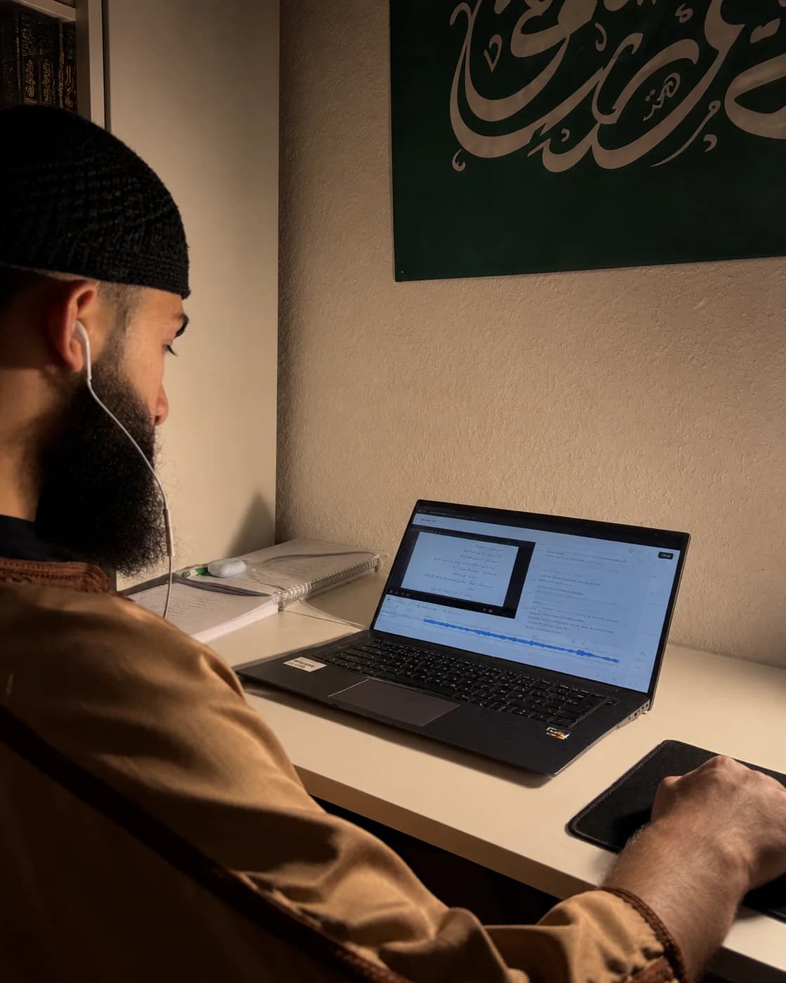 Person lernt am Laptop mit einer deutsch erklärten Madina-Lektion und eigenen Notizen